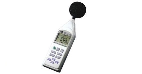 Technician inspecting a sound level meter for acoustic measurement performance